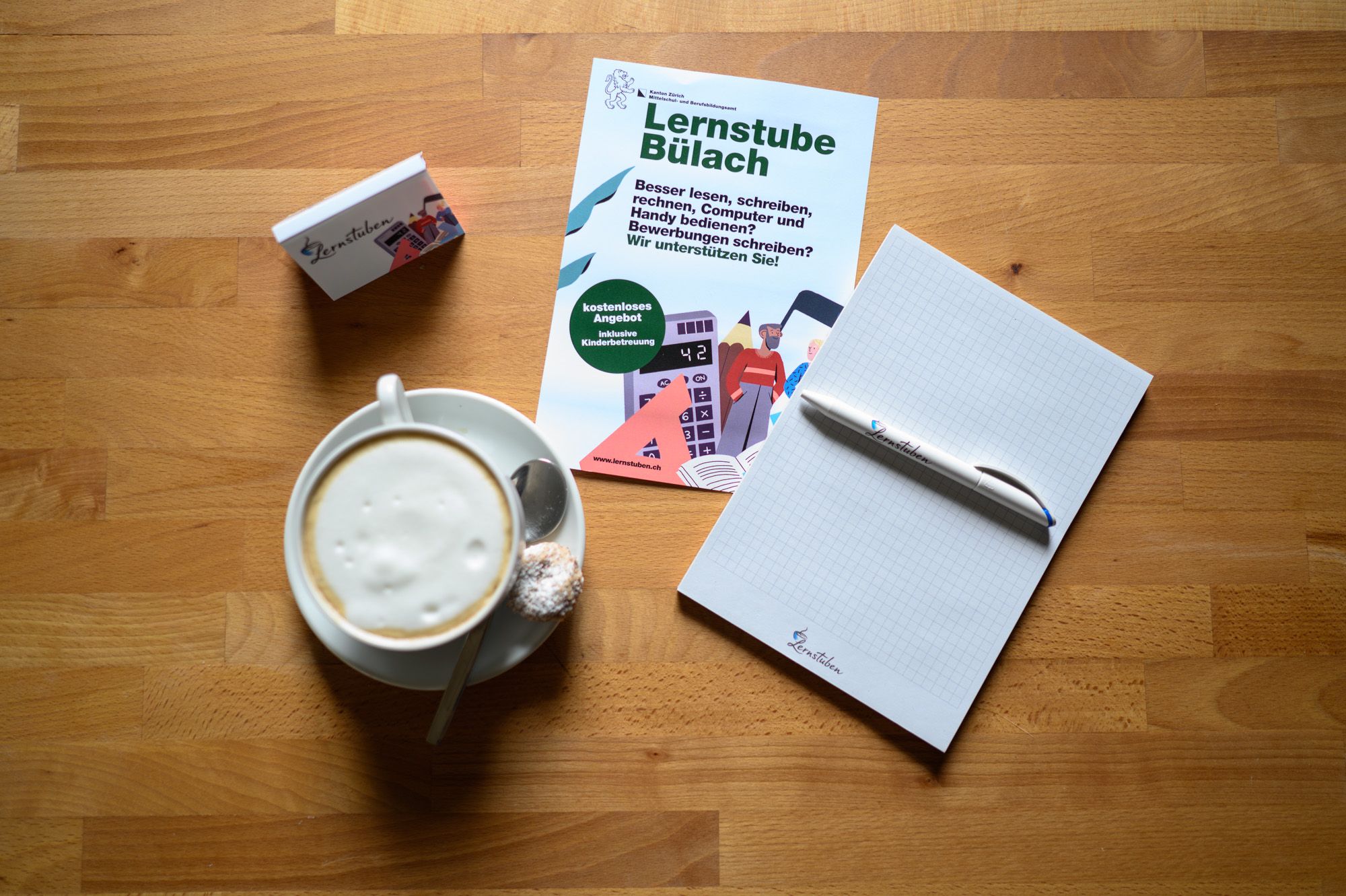 Flyer der Lernstube Bülach und ein Kaffee und Schreibblock