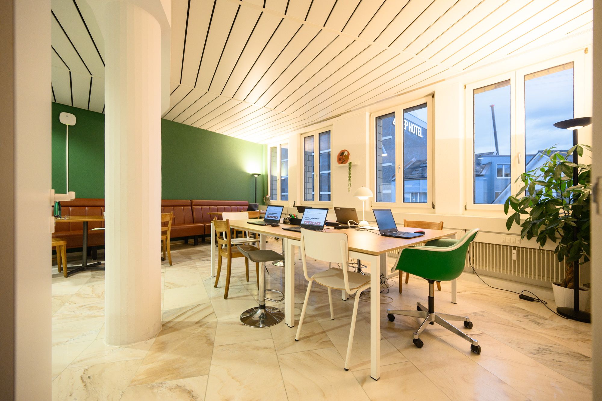 Innenansicht der Lernstube Kloten. Es sind Tische und Stühle in einem gemütlichen Raum zu sehen, mit warmem Licht.