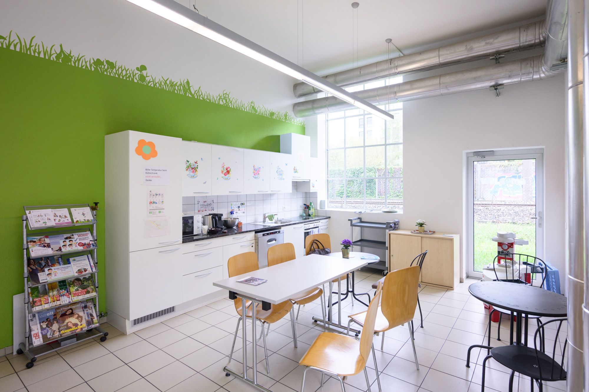 Cafeteria der Lernstube Affoltern mit kleiner Küchenzeile und grossem Tisch in der Mitte des Raumes.