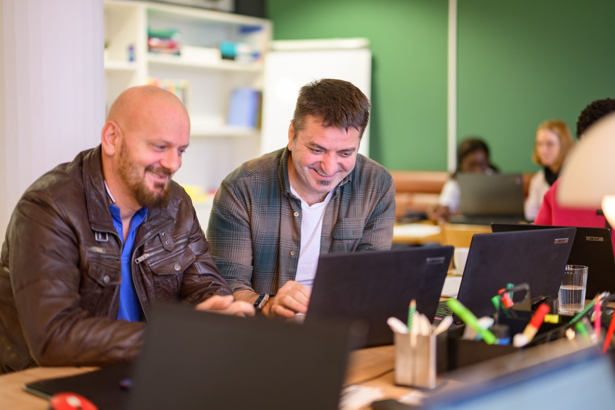 Zwei Besuchende der Lernstuben sitzen gemeinsam an den Laptops und haben Freude am Lernen